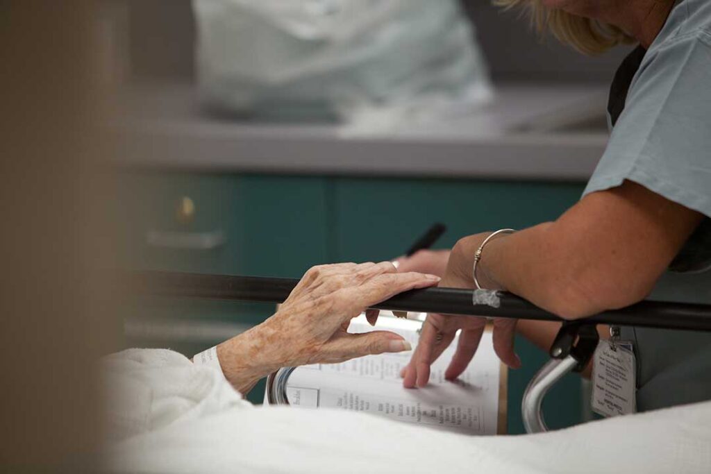 Older adults and children create crafts together around a table in a bright assisted living activity room.